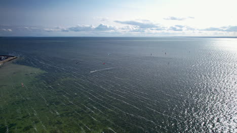 Luftaufnahme-Zeigt-Eine-Gruppe-Von-Kitesurfern-Auf-Der-Ostsee-Während-Des-Goldenen-Sonnenuntergangs-In-Polen