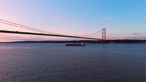 Humber-Bridge-aglow-at-twilight,-with-cars-composing-a-luminous,-scenic-pathway