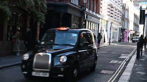 Taxi-driving-on-Beak-Street,-London,-United-Kingdom