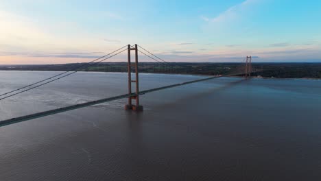 The-allure-of-twilight:-an-aerial-view-of-Humber-Bridge-beneath-the-setting-sun,-where-cars-move-with-rhythmic-elegance