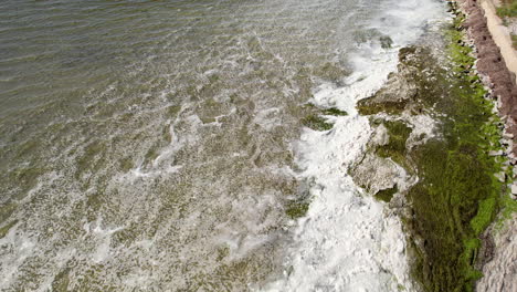 Amazing-footage-of-waves-crashing-onto-the-shoreline,-causing-a-bubbly-white-foam-in-Kuźnica,-Pomerania,-Poland