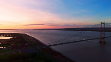 Golden-hour-on-the-Humber-Bridge,-with-cars-creating-a-tranquil-spectacle-in-this-aerial-view