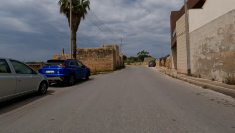 Toma-Panorámica-Desde-Un-Automóvil-Conduciendo-Por-Las-Carreteras-Históricas-De-La-Isla-De-Malta-Con-Vistas-A-Los-Antiguos-Edificios-Mudados-Durante-Un-Emocionante-Viaje-En-Verano.