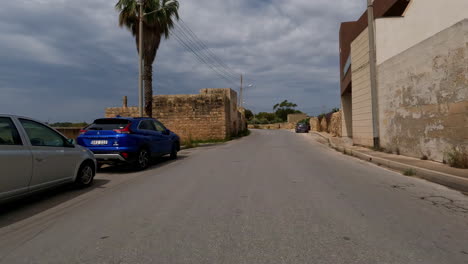 POV-Weitwinkelaufnahme-Von-Einer-Autofahrt-Auf-Den-Historischen-Straßen-Auf-Der-Insel-Malta-Mit-Blick-Auf-Die-Alten,-Verfallenen-Gebäude-Während-Einer-Aufregenden-Reise-Im-Sommer