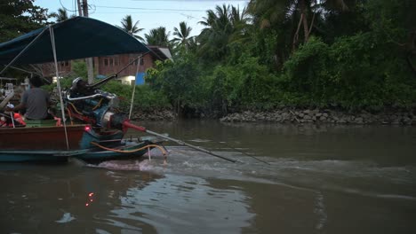 Ein-Langes-Boot,-Beladen-Mit-Touristen,-Die-Ihre-Schwimmwesten-Tragen-Und-Die-Flusslandschaft-Des-Schwimmenden-Marktes-Von-Amphawa-In-Thailand-Genießen