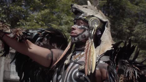 Slow-motion-close-up-shot-of-a-man-in-a-tribal-outfit-performing-on-the-street