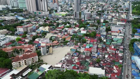 Aerial-view-of-densely-packed-houses-by-highway-in-Manila,-Philippines-in-day
