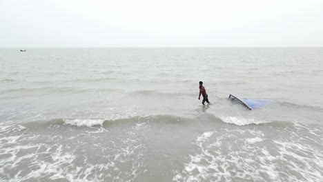 Pescador-Tirando-Una-Red-De-Pesca-Sobre-El-Paisaje-Marino-De-La-Bahía-De-Bengala,-En-La-Playa-De-Kuakata-En-Patuakhali,-Bangladesh