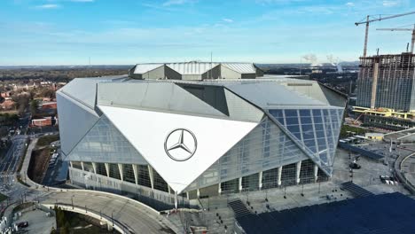 Ascending-drone-shot-above-modern-Mercedes-Benz-Stadium-in-Atlanta-City-at-sunlight---tilt-down