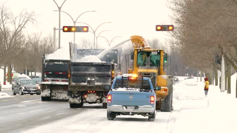 Ein-Schneepflug-Räumt-Die-Straße-Und-Spritzt-Den-Schnee-Auf-Einen-Neben-Ihm-Fahrenden-Lastwagen