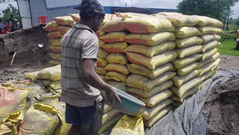 A-heap-of-bags-of-cement-in-a-construction-site-with-lots-of-sand---construction-idea-concept