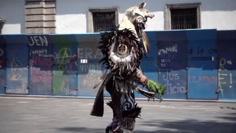 Toma-En-Cámara-Lenta-De-Un-Hombre-Vestido-Con-Ropa-Tribal-Bailando-En-Las-Calles-De-La-Ciudad-De-México