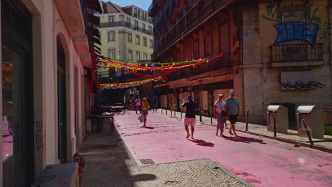 Calles-Estrechas-De-Lisboa-Iluminadas-Por-El-Sol-Mientras-La-Gente-Hace-Turismo