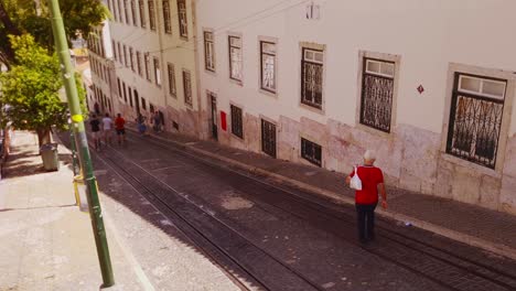 Die-Bewohner-Lissabons-Gehen-Einen-Stadthang-Hinauf-Und-Hinunter-Und-überqueren-Dabei-Straßenbahngleise
