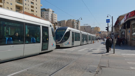 Mass-rapid-transit-light-rail-line-zooms-across-and-people-quickly-cross-road