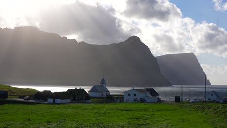 Sunrays-through-clouds-over-Faroese-landscape-in-Vidareidi,-Faroe-Islands