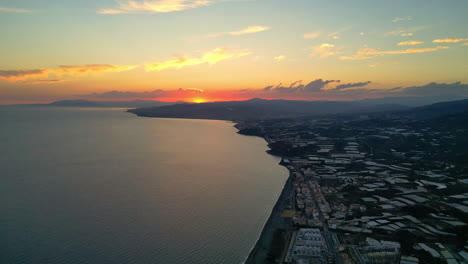 Aerial-backward-overview-of-the-Costa-Del-Sol,-Sunshine-coast,-sunset-in-Spain