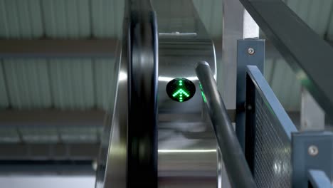 Green-arrow-pointing-upwards-to-access-the-escalator-at-a-train-station-in-Bangkok,-Thailand