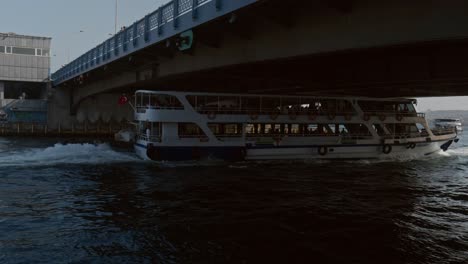 Double-decked-cruise-ferry-boat-sails-under-low-Galata-bridge-Golden-Horn