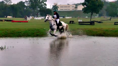 A-White-horse-and-rider-jump-over-an-obstacle-during-a-cross-country-race