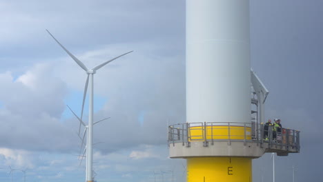 Smiling-maintenance-crew-off-shore-wind-park,-CLOSE-UP-from-a-passing-vessel