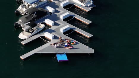 a-group-of-friends-enjoying-their-time-on-a-boat-dock-taking-in-the-sun-on-Lake-Arrowhead-california-AERIAL-TRUCKING