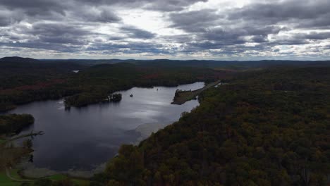 Aerial-view-of-the-countryside-in-Stormville,-New-York-on-a-cloudy-day-in-the-fall-with-Black-Pond-in-view