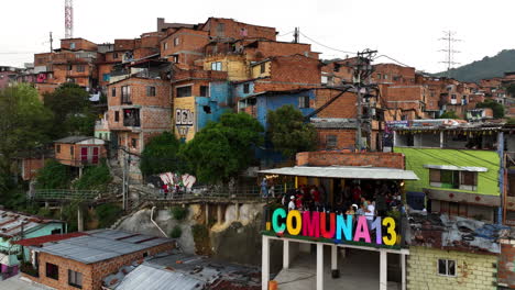Aerial-view-of-the-Comuna-13-sign-in-a-favela-community-of-Medellín,-Colombia