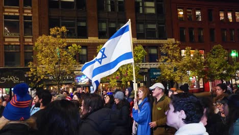 A-woman-holds-an-Israeli-flag-at-a-Support-Israel-rally-in-Portland-Maine