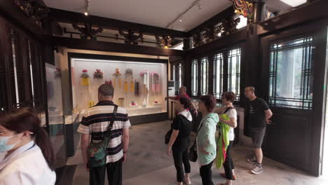 Chinese-tourists-walk-in-the-exhibition-hall-of-Traditional-Chinese-Opera-centre-in-Guangzhou,-China