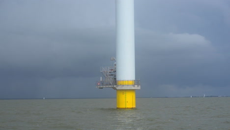 Navegando-Cerca-Del-Fondo-De-Una-Gran-Turbina-Eólica-De-Un-Parque-Eólico-Cercano-A-La-Costa-En-Un-Lago-De-Agua-Dulce