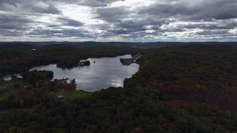 Aerial-view-of-the-countryside-in-Stormville,-New-York-on-a-cloudy-day-in-the-fall-with-Black-Pond-in-the-shot