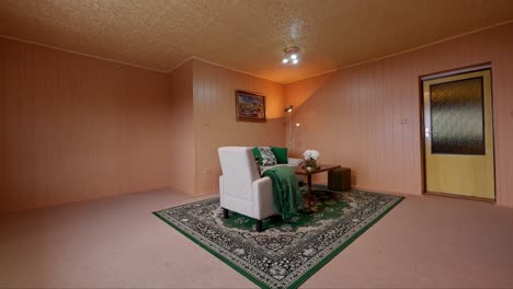 Side-dolly-shot-of-an-old-czech-livingroom-with-green-carpet-grey-sofa-and-brown-plastic-plates-on-the-wall