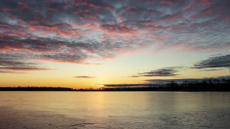 Friedlicher-Zeitraffer-Von-Wolken-Und-Sonnenuntergang-Mit-Einem-Friedlichen-See-Im-Vordergrund