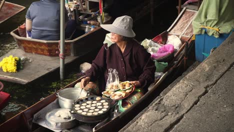 Frau-Kocht-Asiatische-Leckereien-Auf-Dem-Schwimmenden-Markt-In-Thailand