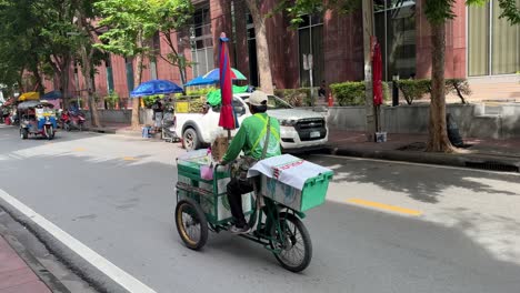 Lokaler-Händler-Radelt-Mit-Seinem-Dreirad-LKW-Auf-Der-Straße-In-Saladaeng,-Bangkok,-Thailand