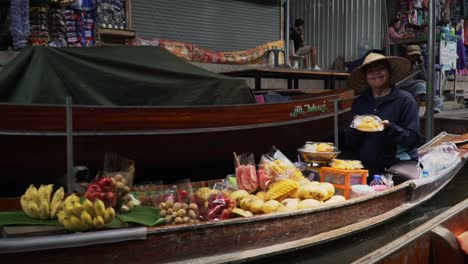 Mujer-Exhibiendo-Frutas-A-La-Venta-En-El-Mercado-Flotante-En-Asia