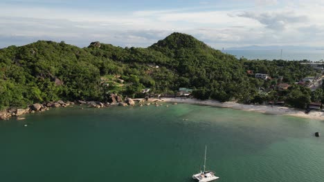 Panoramic-view-of-paradise-island-Koh-Samui,-Thailand,-passing-by-a-catamaran-in-emerald-green-waters