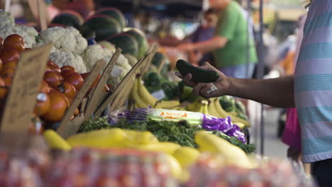 Slow-motion-shot-of-an-African-American-man-selecting-fresh-vegetables-from-a-market