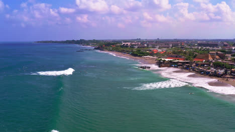 Big-sea-foamy-waves-hitting-sandy-beach-in-Canggu-in-Bali,-Indonesia