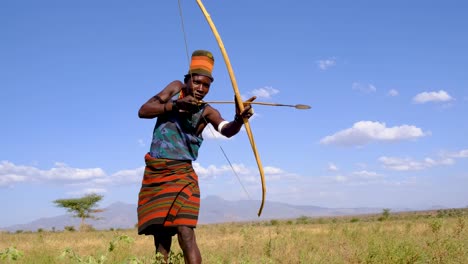Porträt-Eines-Karamojong-Jägers,-Der-Während-Der-Schuppentierjagd-In-Uganda,-Afrika,-Einen-Pfeil-Schießt