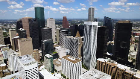 Aerial-view-rising-in-front-of-the-skyline-of-downtown-Houston,-sunny-Texas,-USA
