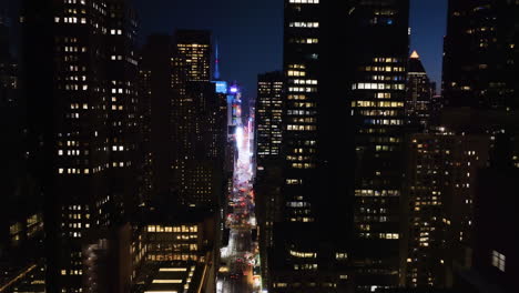 Aerial-view-in-middle-of-buildings-on-the-7th-ave,-toward-Times-square,-night-in-NY