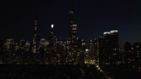 Panoramic-drone-shot-in-front-of-the-Billionaires'-Row-skyline,-night-in-New-York