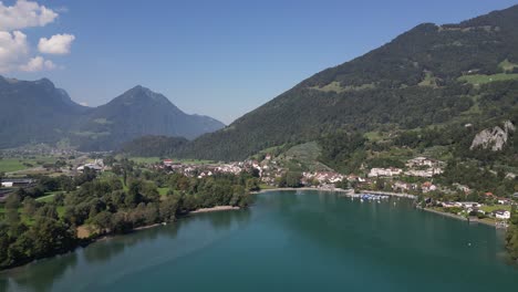 Drone-flying-above-along-Weesen-town-based-near-shore-of-Walensee-lake,-Switzerland