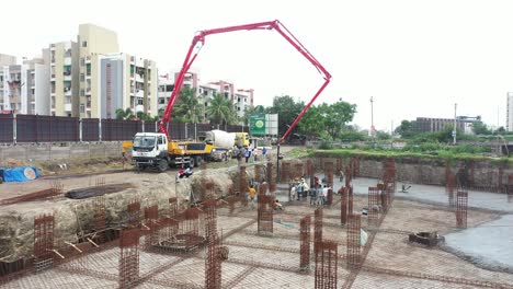 Vista-Aérea-Del-Suelo,-Se-Están-Realizando-Trabajos-De-Construcción-De-Un-Edificio-De-Gran-Altura-En-El-Que-Se-Está-Construyendo-El-Sótano-Y-Se-Está-Rellenando-Hormigón-Y-Cemento