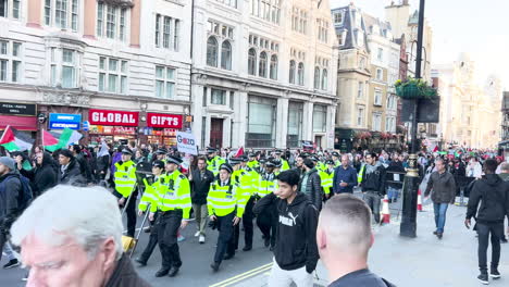 Crowded-street-with-protesters,-police-presence,-and-historic-buildings---Center-of-London