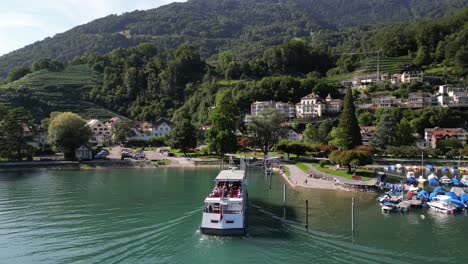 great-big-ship-of-white-colour-with-plenty-people-on-board-from-their-cruising-experience-viewing-exploring-the-area-coming-back-to-dock-parking-up-visitors-finishing-their-expedition-trip-sailing