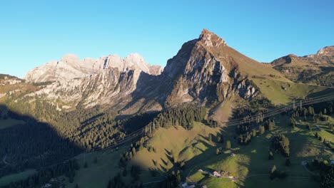 Aerial-shot-of-Swiss-alps-and-a-lake-situated-in-the-valley-near-the-forest