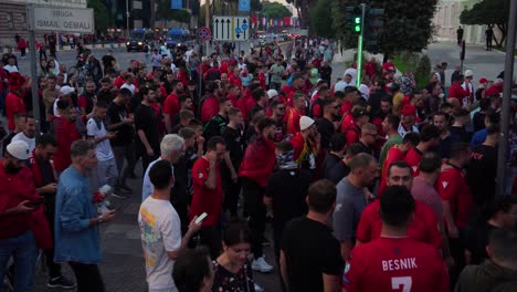Menge-Albanischer-Fußballfans-In-Mannschaftstrikots,-Die-Vor-Dem-Spiel-Gegen-Die-Tschechische-Republik-Auf-Den-Straßen-Von-Tirana-Jubeln